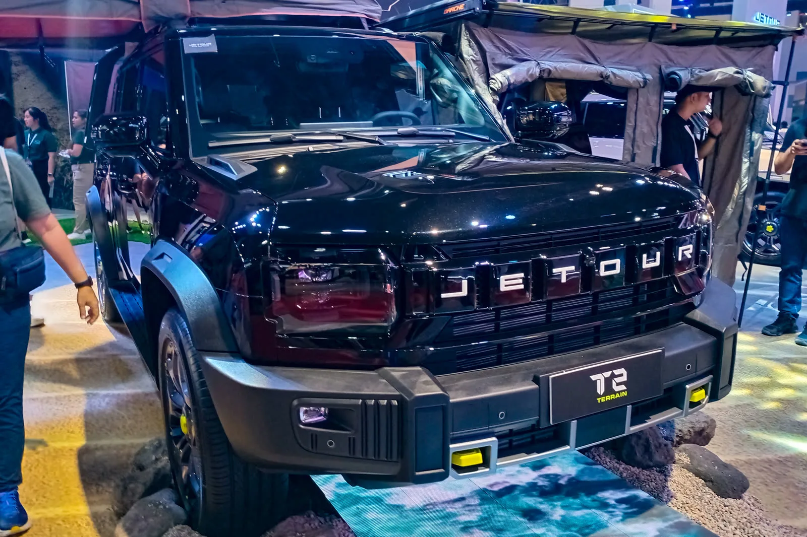 A lime-green Jetour T2 Terrain on a motor show stand